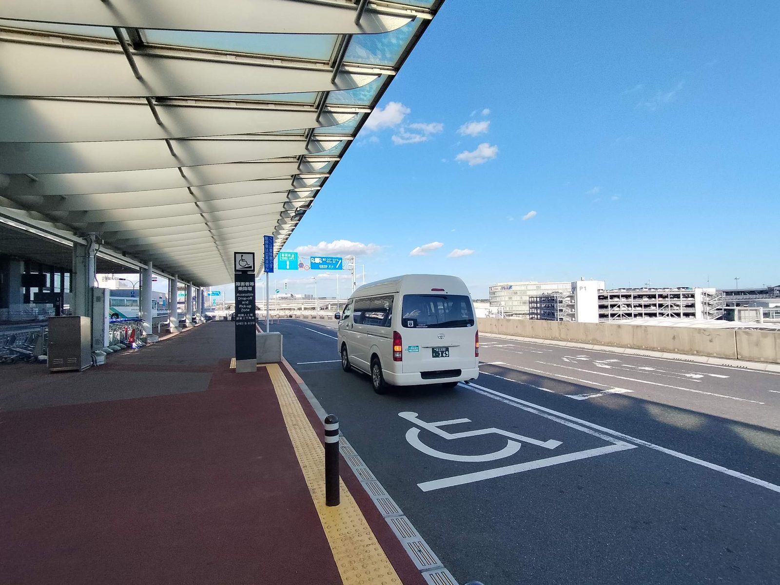 成田空港の障害者等乗降場から出発する介護タクシー（第2・第3ターミナル方面の案内標識）