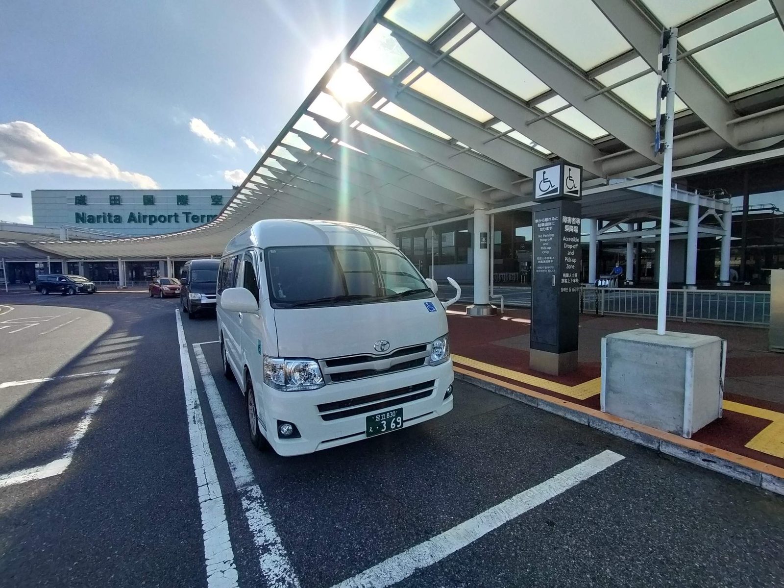 成田空港 第1ターミナル（北ウイング）の障害者等乗降場に停めたアールケアTAXIの介護タクシー（ハイエース）