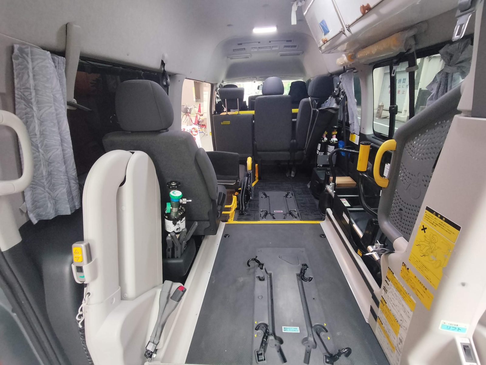 介護タクシーの車内（後ろから見た様子）。車いすの固定具と酸素ボンベ