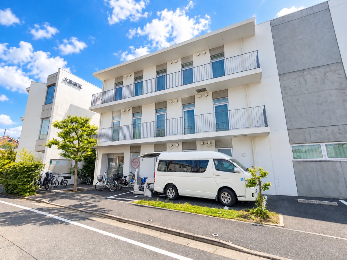 大高病院（足立区島根）の外観と、前に停まる車いす対応の福祉車両